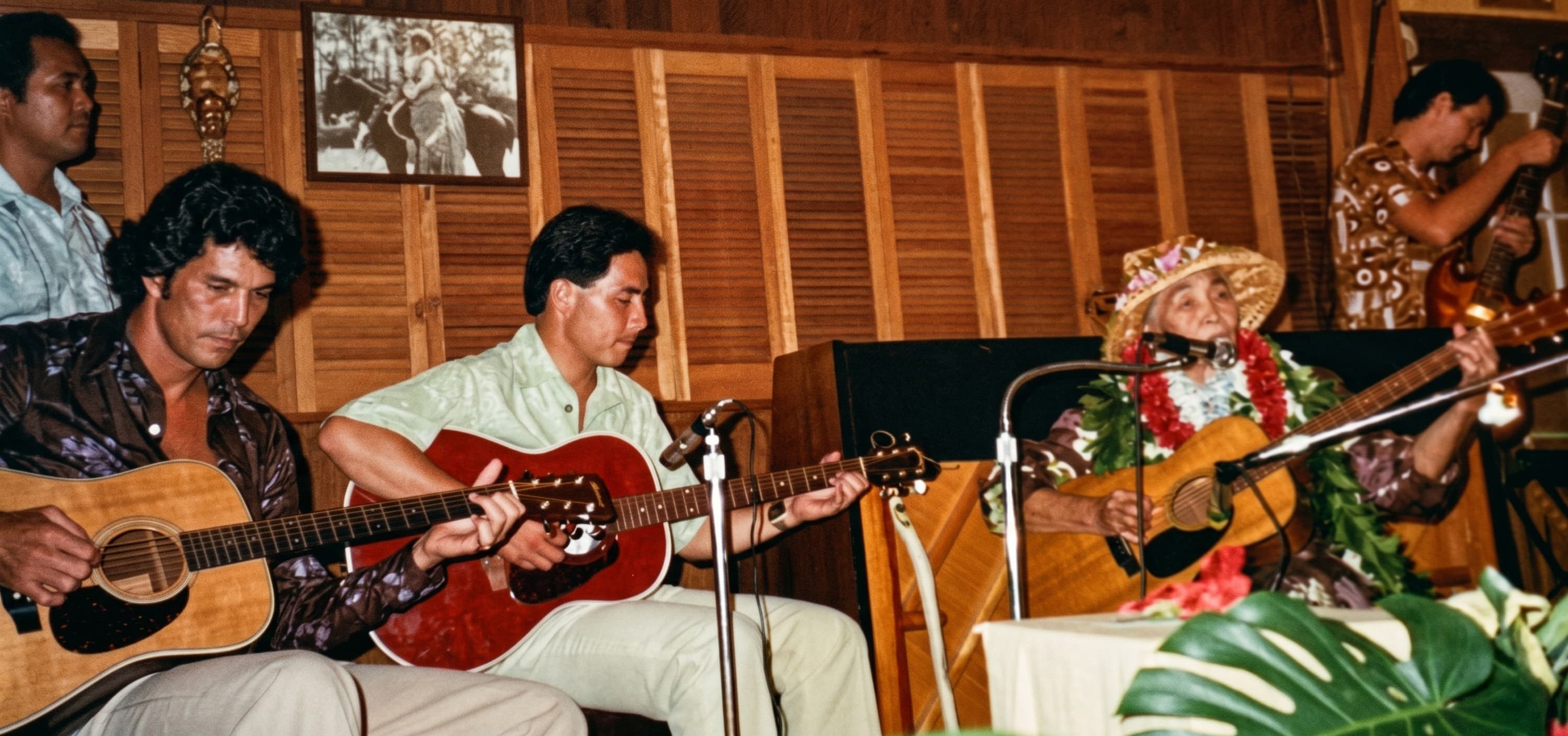 Palani Elua (far left) playing slack key guitar with Aunty Alice Nāmakelua